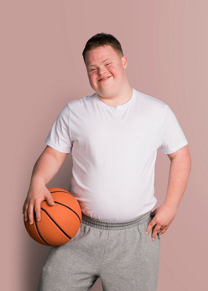 Cute athletic boy with down syndrome holding a basketball 
