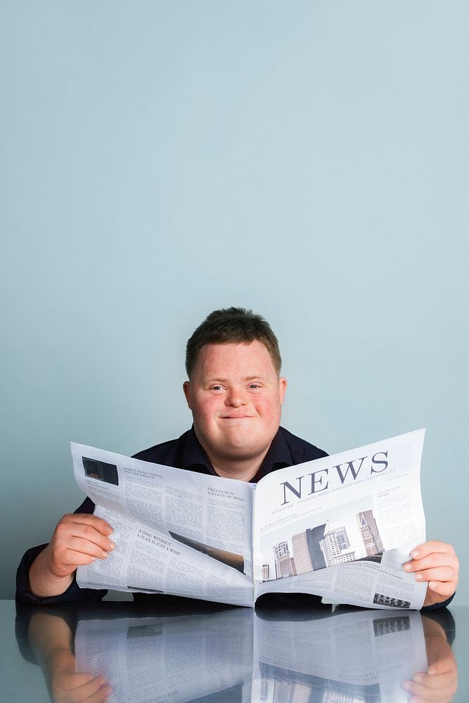 Boy with down syndrome reading a newspaper during the coronavirus pandemic