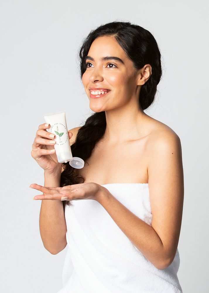 Cheerful woman squeezing cream from a tube mockup