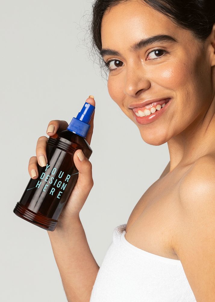 Cheerful woman using a sunscreen spray bottle mockup