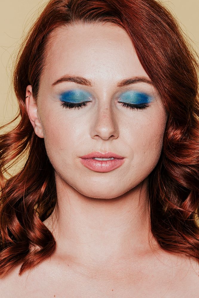 Red headed woman wearing 80s makeup 