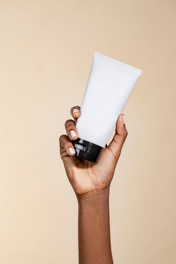Black woman holding an unlabeled cream tube