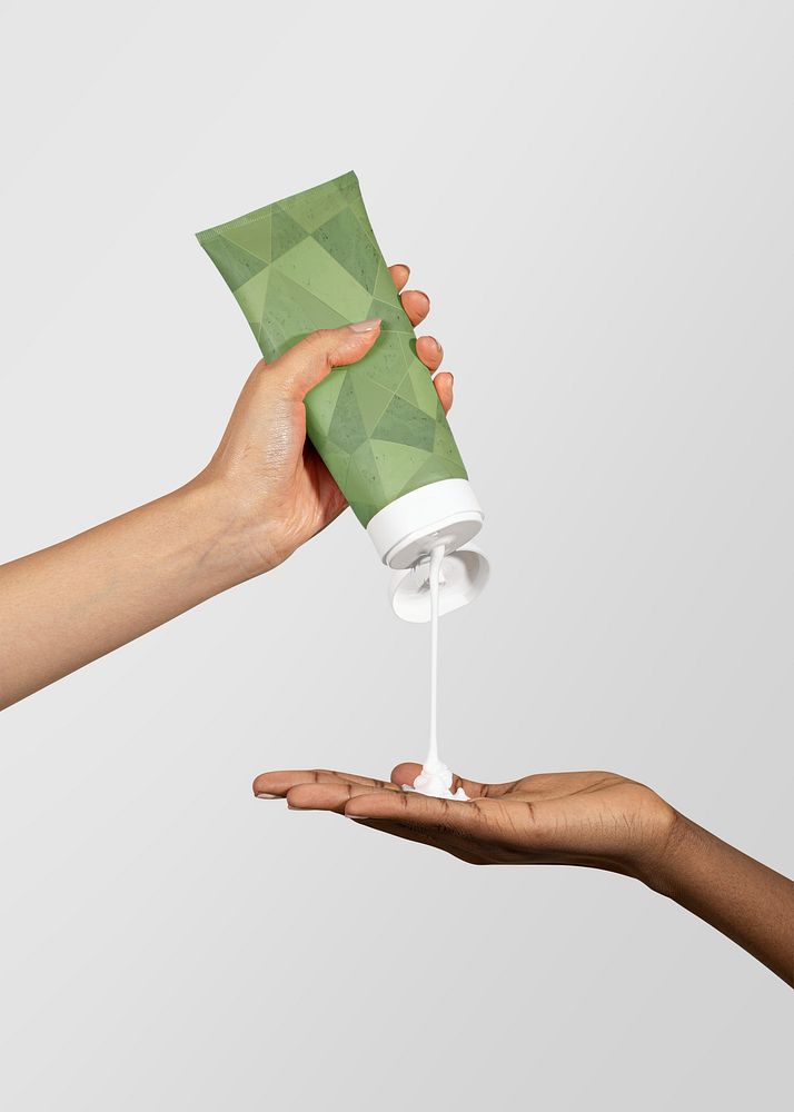 Woman squeezing cream from a beige tube psd mockup