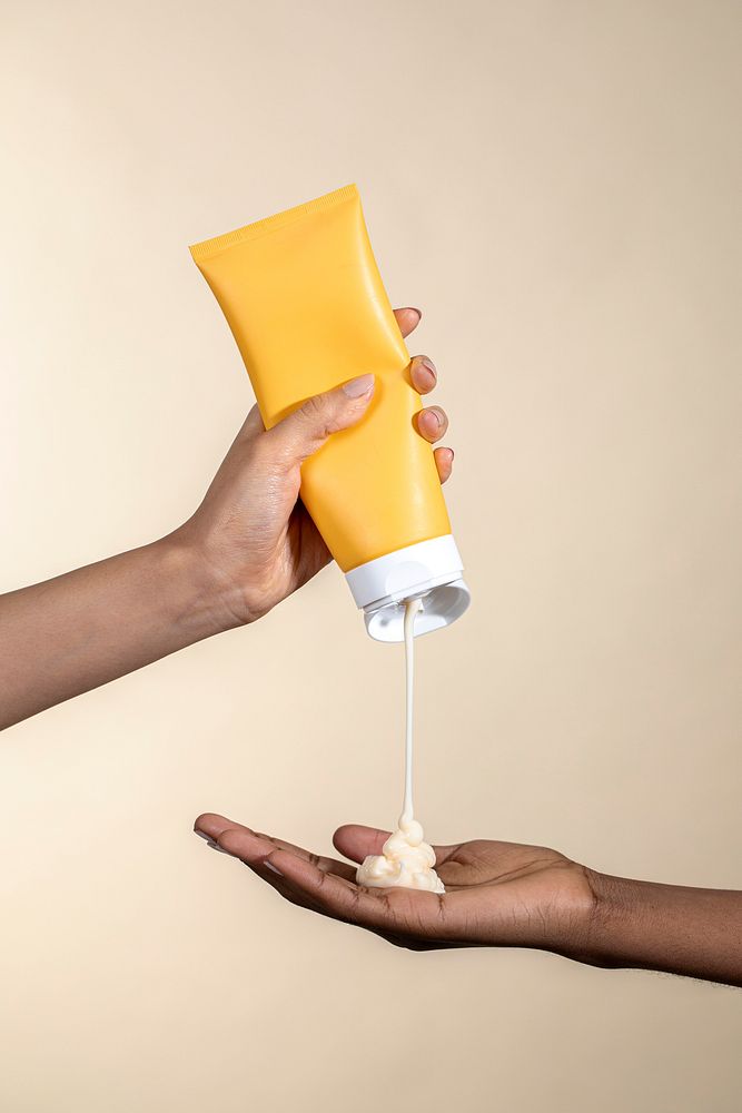 Woman squeezing cream from an unlabeled yellow tube