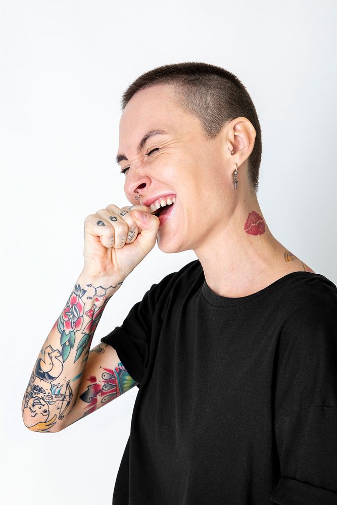 Skinhead model with tattoos in black T shirt laughing