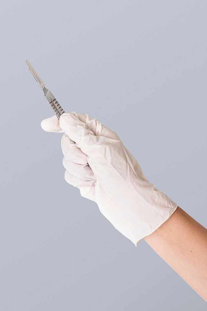 Doctor's hand in a white glove holding a scalpel mockup