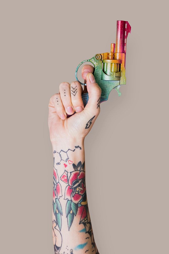 Hand with tattoo holding gun raising up mockup