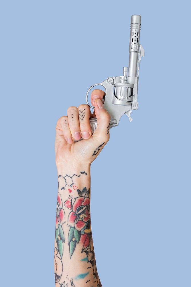 Hand with tattoo holding gun raising up mockup