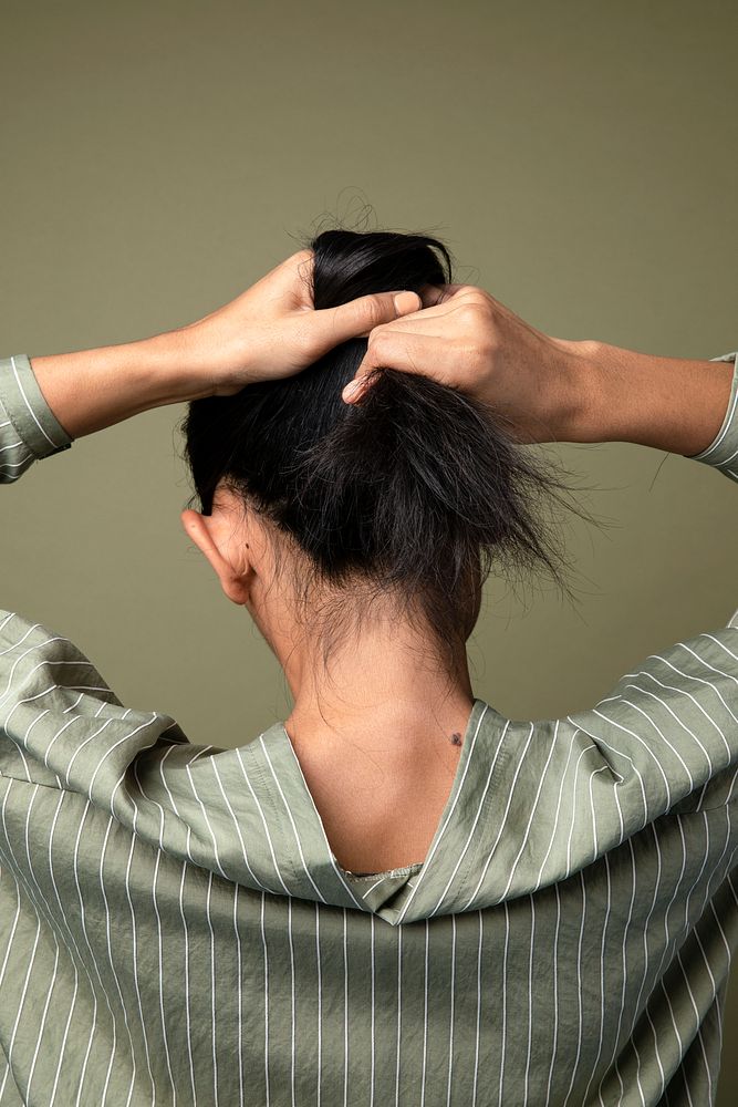 Rear view of a woman putting her long hair up