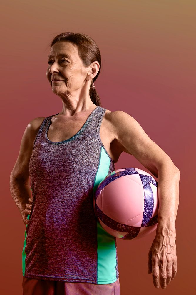 Sporty old lady in sports outfit with a medicine ball