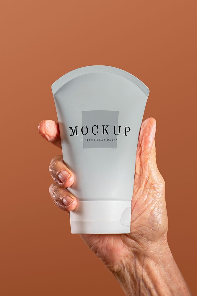 Hand holding a facial cream tube container mockup