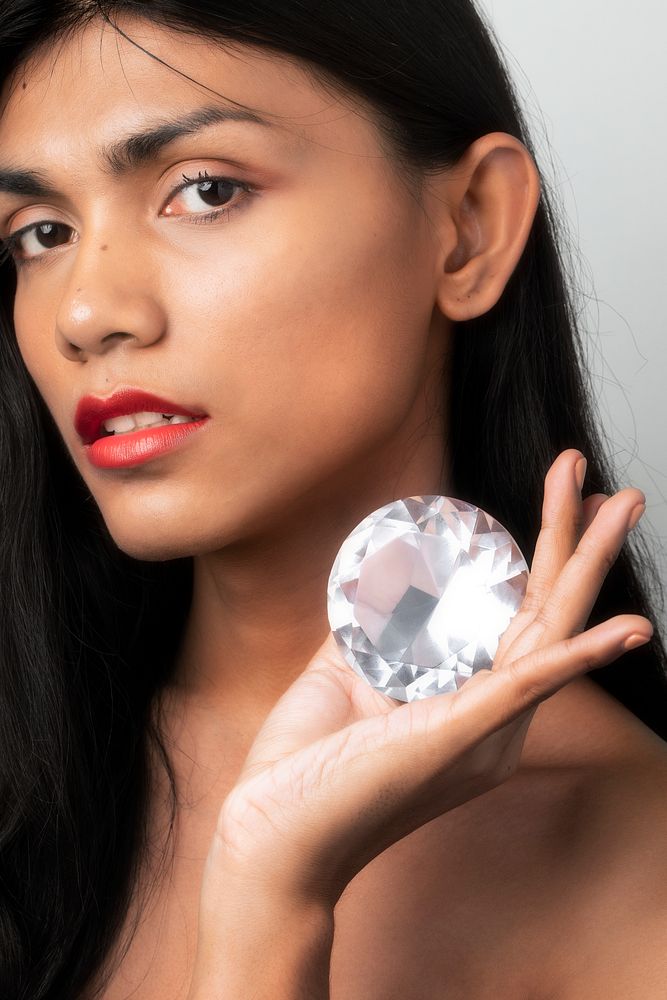 Beautiful woman holding a big diamond in her hand
