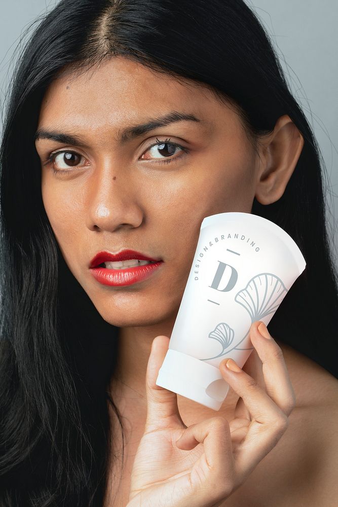 Woman holding a white facial cream container mockup