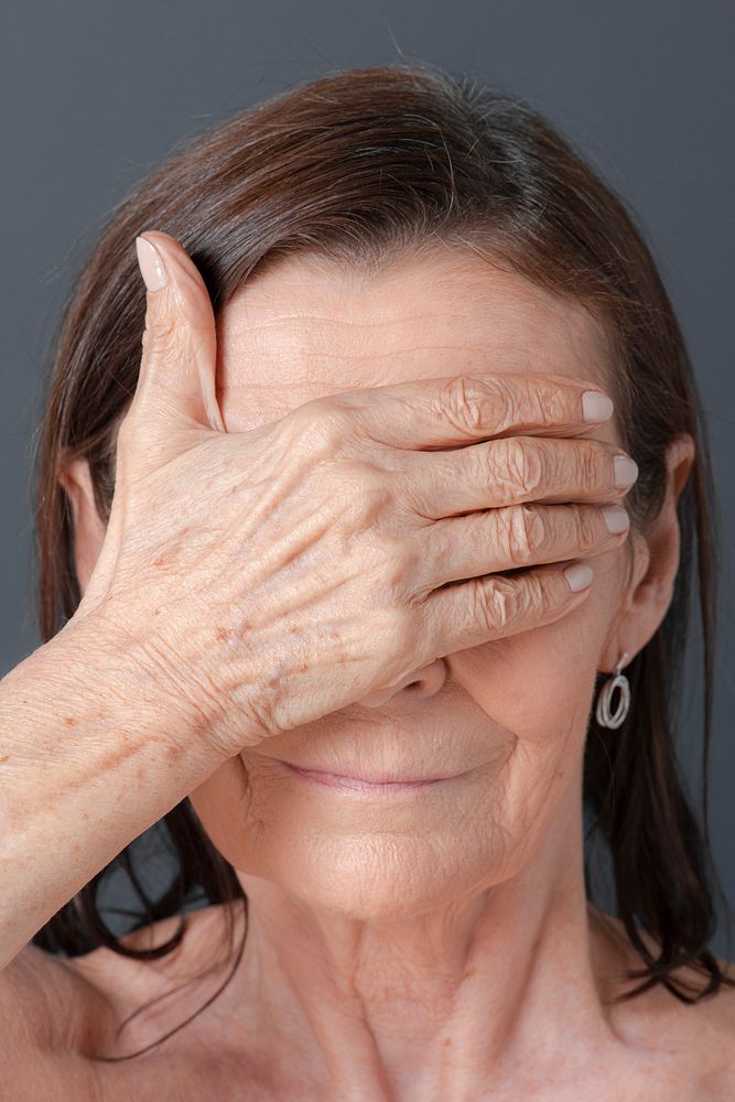 Close up of a senior woman covering her eyes