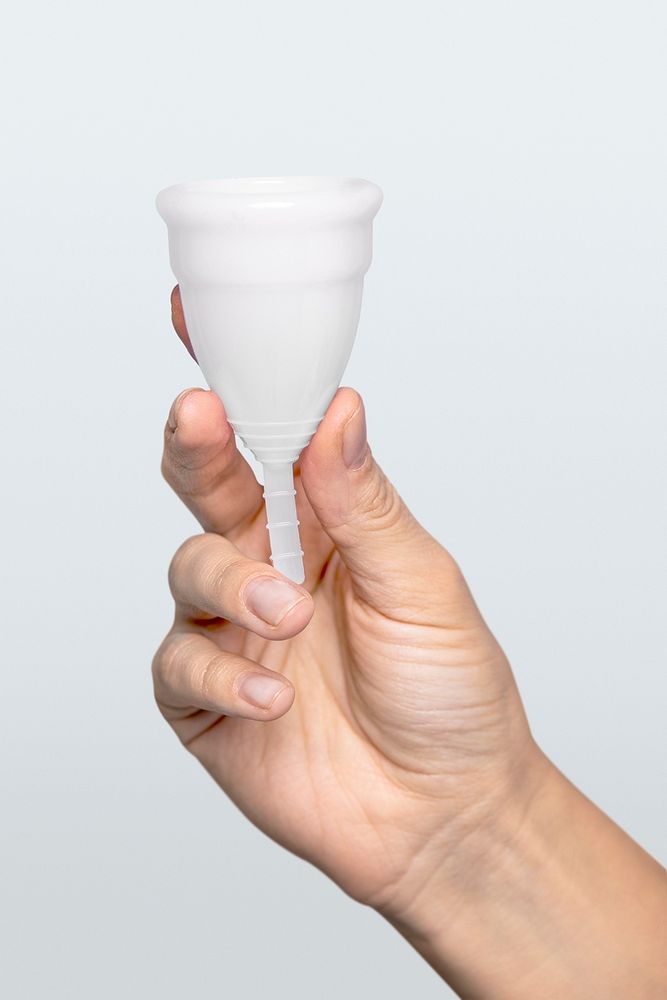 Hand holding white menstrual cup mockup