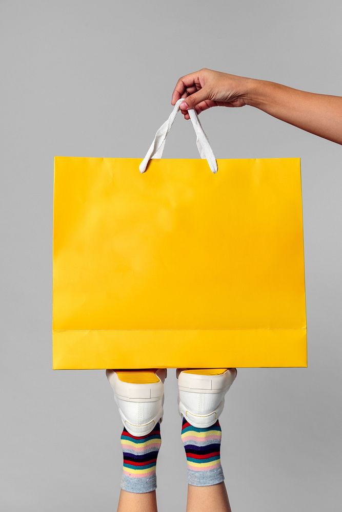 Woman carrying a yellow shopping bag