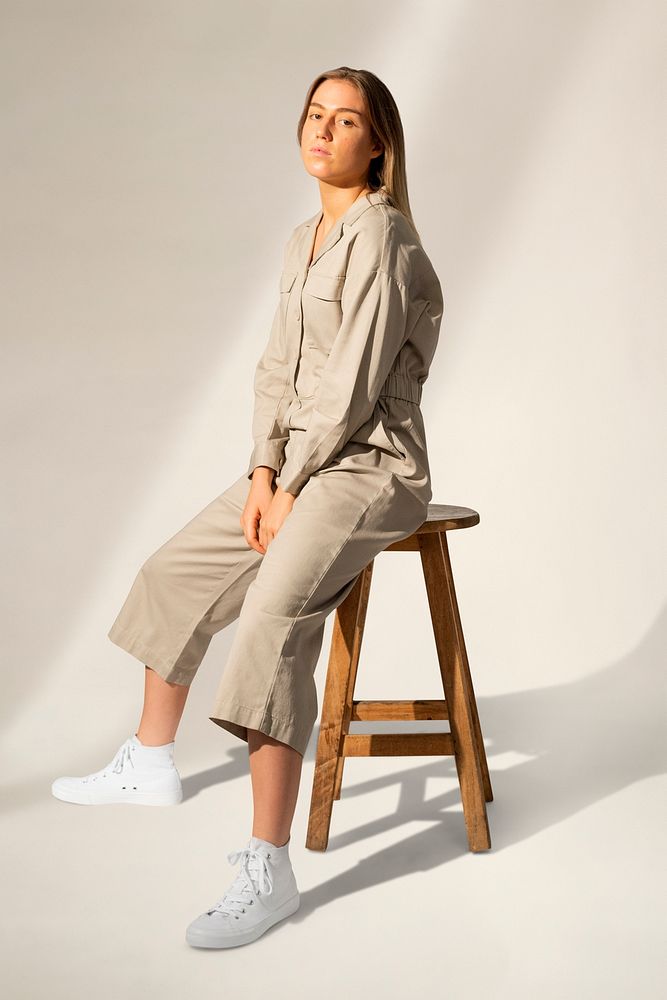 Woman in jumpsuit mockup psd sitting on a chair streetwear fashion