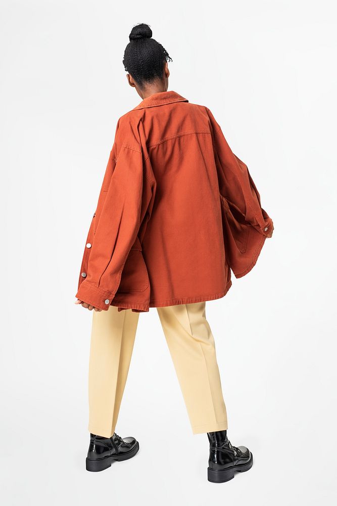 Woman in orange oversized jacket street style apparel rear view