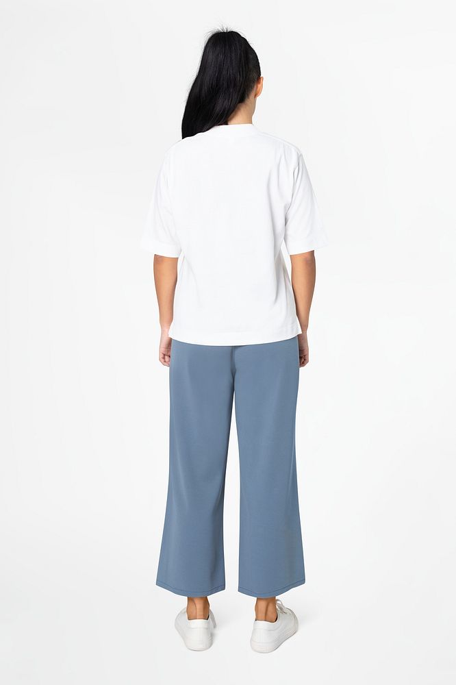 Woman in white tee and blue loose pants minimal fashion rear view