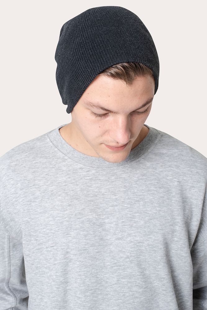 Handsome man in black beanie and gray sweater winter apparel studio shoot