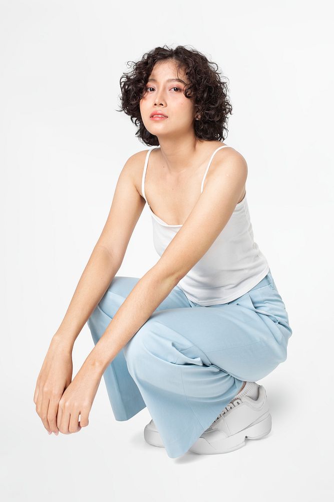 Woman sitting and posing in simple outfit full body