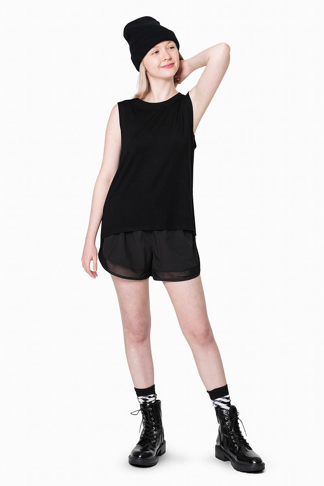 Blonde girl in black tank top and shorts with beanie for street fashion shoot