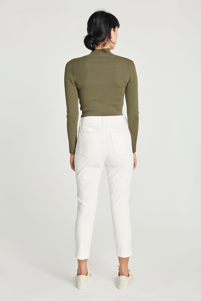 Women in a green turtleneck top and white pants outfit