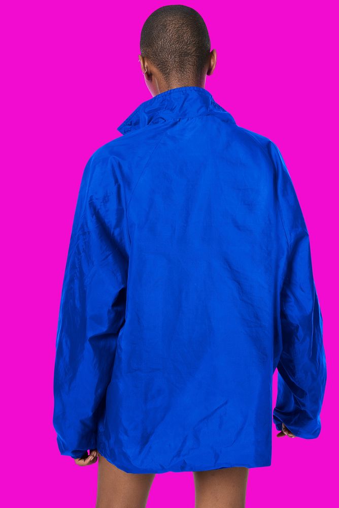 Black woman wearing a blue waterproof jacket on a fluorescent pink background 