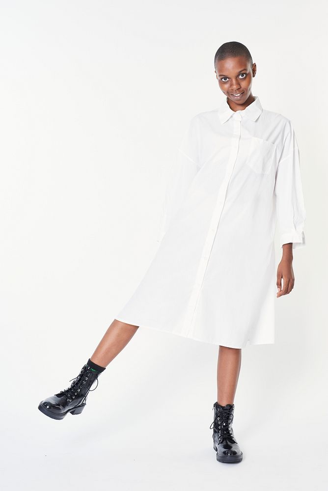 Black woman wearing black ankle boots in a white dress
