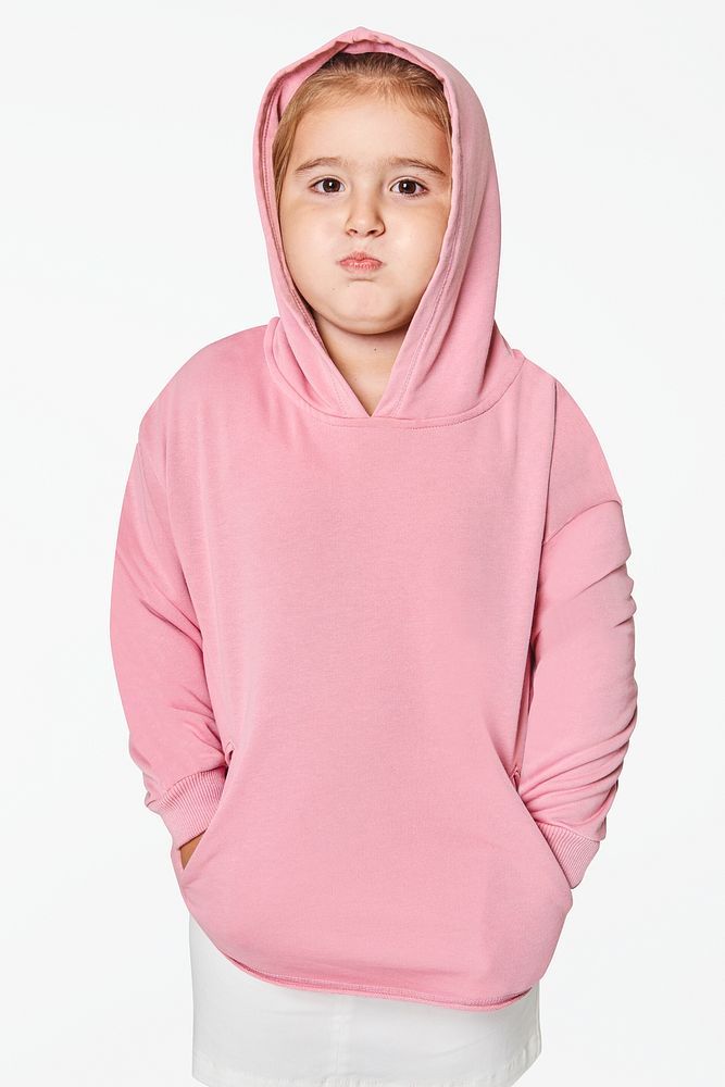 Little cute girl in pink hoodie in studio
