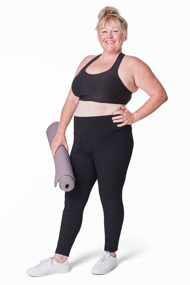 Attractive curvy woman sportswear apparel with yoga mat studio shot