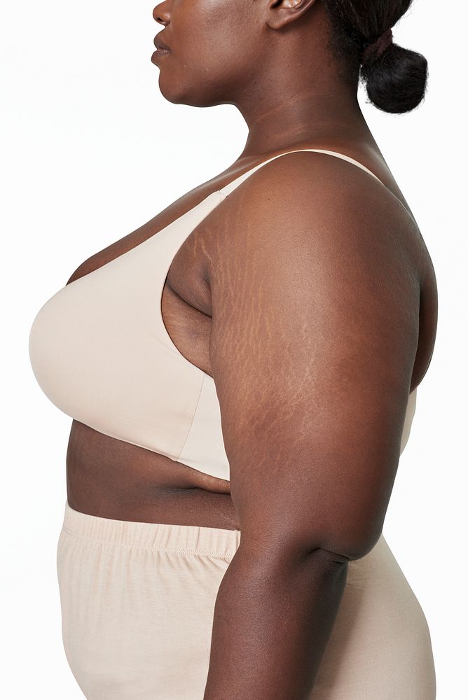 Body positivity beige lingerie plus size model posing facing side