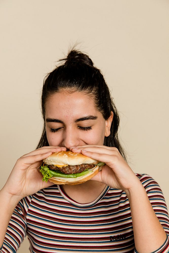 Hamburger lunch, hungry girl eating a burger