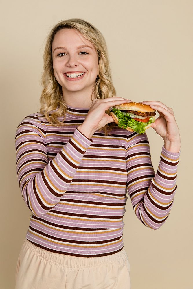 Happy woman eating a hamburger for lunch