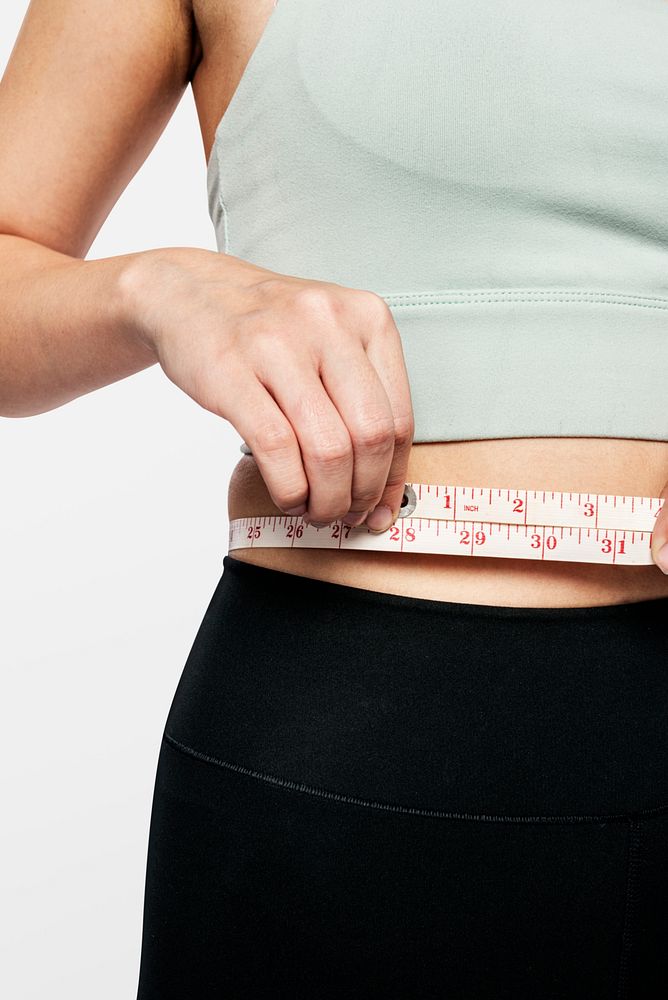 Active woman measuring her waist