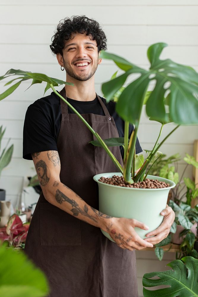 Small business owner holding a potted plant at the shop