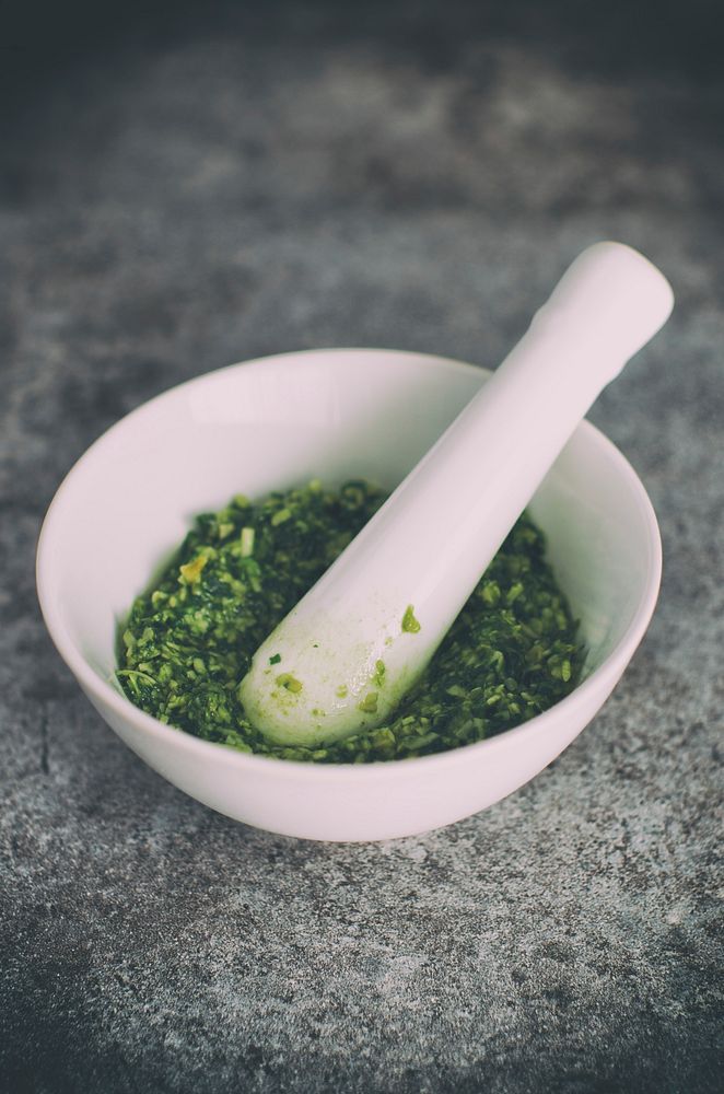 Making pesto with a mortar and pestle. Original public domain image from Wikimedia Commons