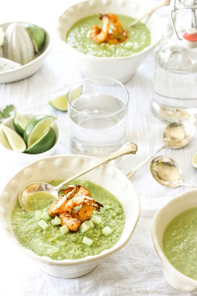 Bowls of green gazpacho soup with shrimp, limes, and cucumbers for a light dinner. Original public domain image from…