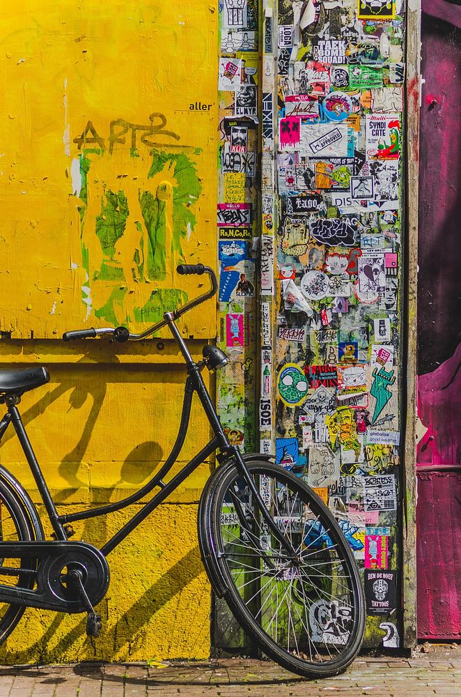 Bike leaning against the yellow wall in Stickerrific. Original public domain image from Wikimedia Commons