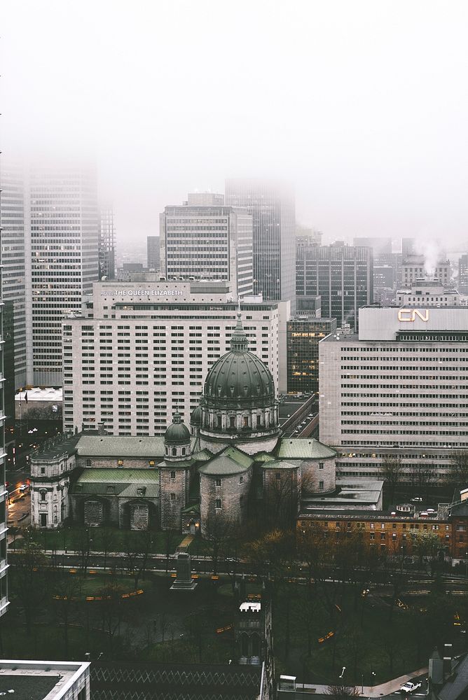 Cathedral-Basilica of Mary Queen of the World and high-rises in Montreal on a foggy day. Original public domain image from…