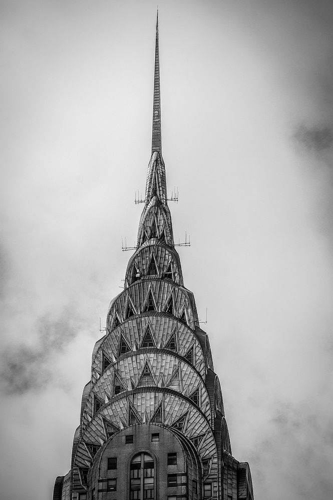 Black and white photo of the top of the Chrysler Building in New York City. Original public domain image from Wikimedia…