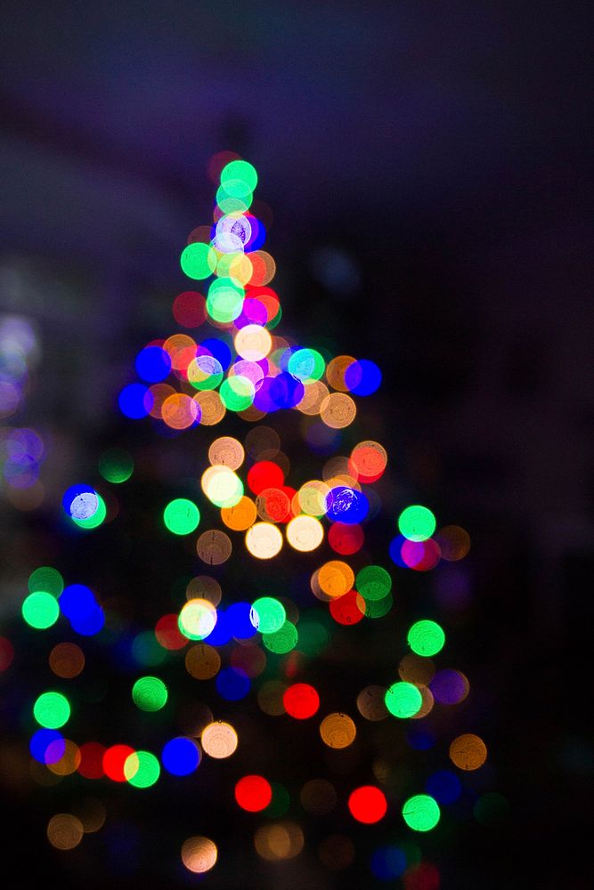 The out-of-focus, festive lights on a Christmas tree create a visual blur of dark and light. Original public domain image…