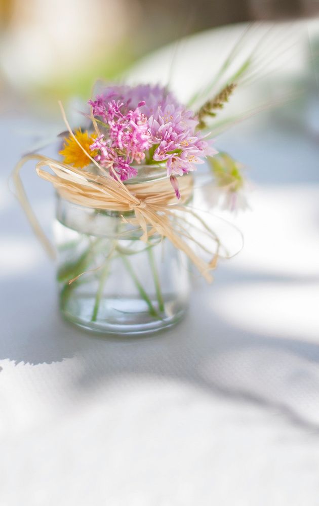 Pink flower in glass jar tied with twine on white table in Spring. Original public domain image from Wikimedia Commons