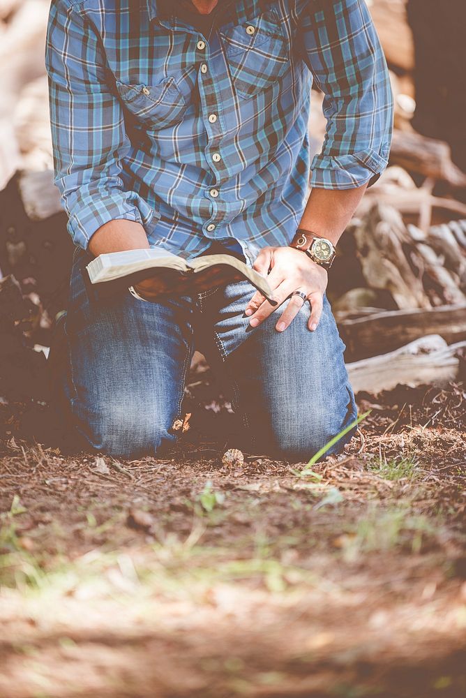 Person reading book while kneeling. Original public domain image from Wikimedia Commons