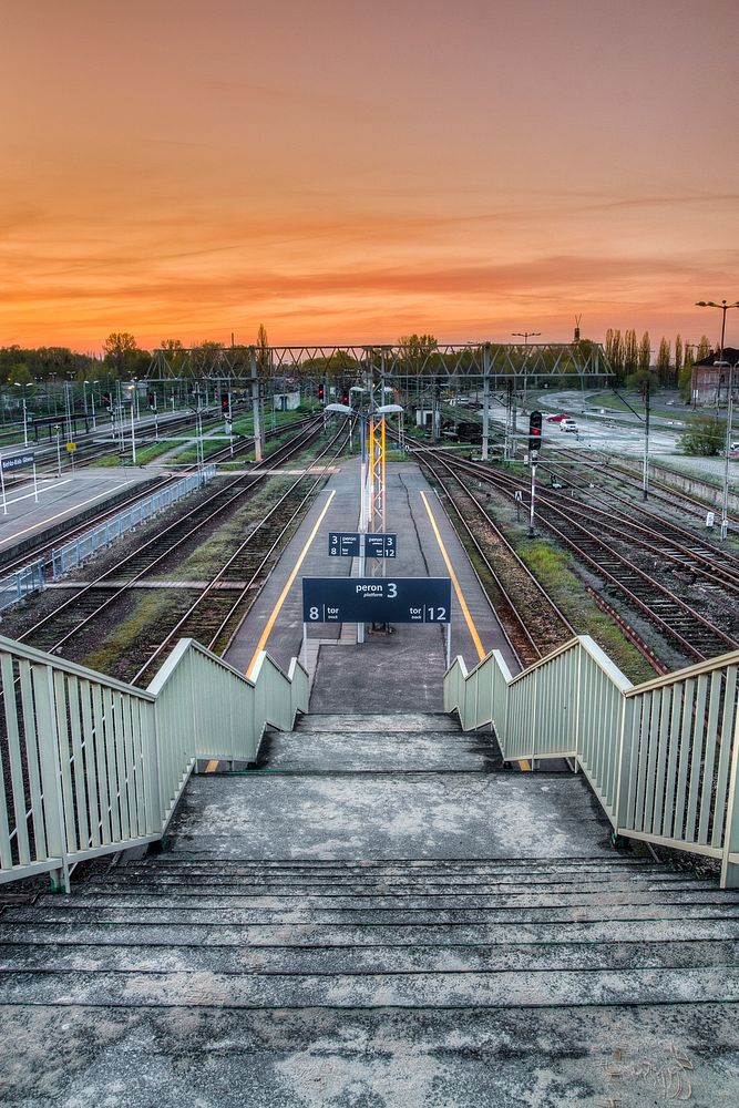 Looking down a staircase from a railway platform during the sunset. Original public domain image from Wikimedia Commons