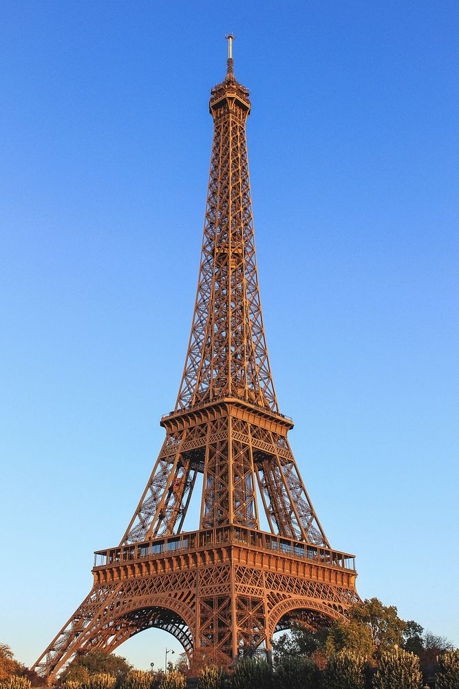 A full view of the Eiffel Tower in Paris with clear blue skies behind it. Original public domain image from Wikimedia Commons