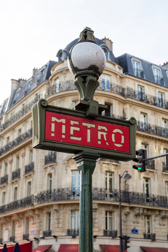 A metro sign in Paris, France with buildings in the background. Original public domain image from Wikimedia Commons