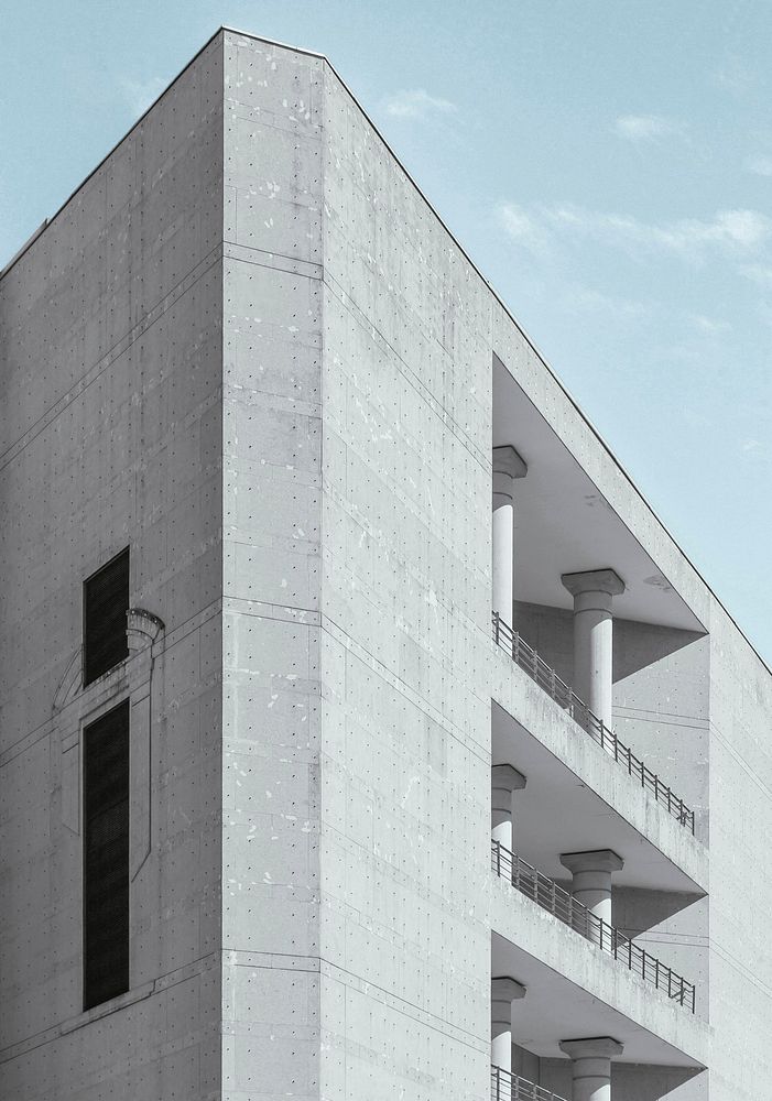 A gray concrete building with columns on its balconies. Original public domain image from Wikimedia Commons