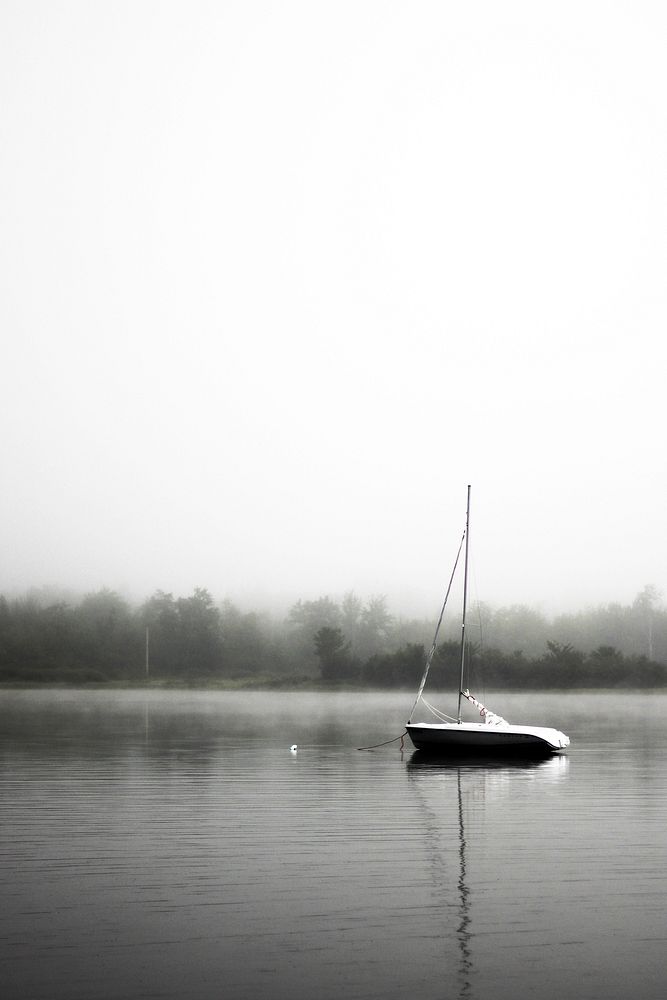 Sailboat sitting on a still lake on a foggy day. Original public domain image from Wikimedia Commons