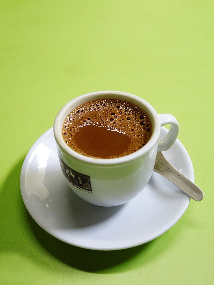Free coffee cup in white saucer with green background photo, public domain beverage CC0 image.
